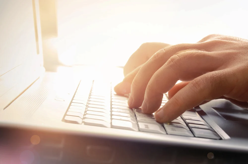 hands on a laptop keyboard working on generative engine optimization for behavioral health