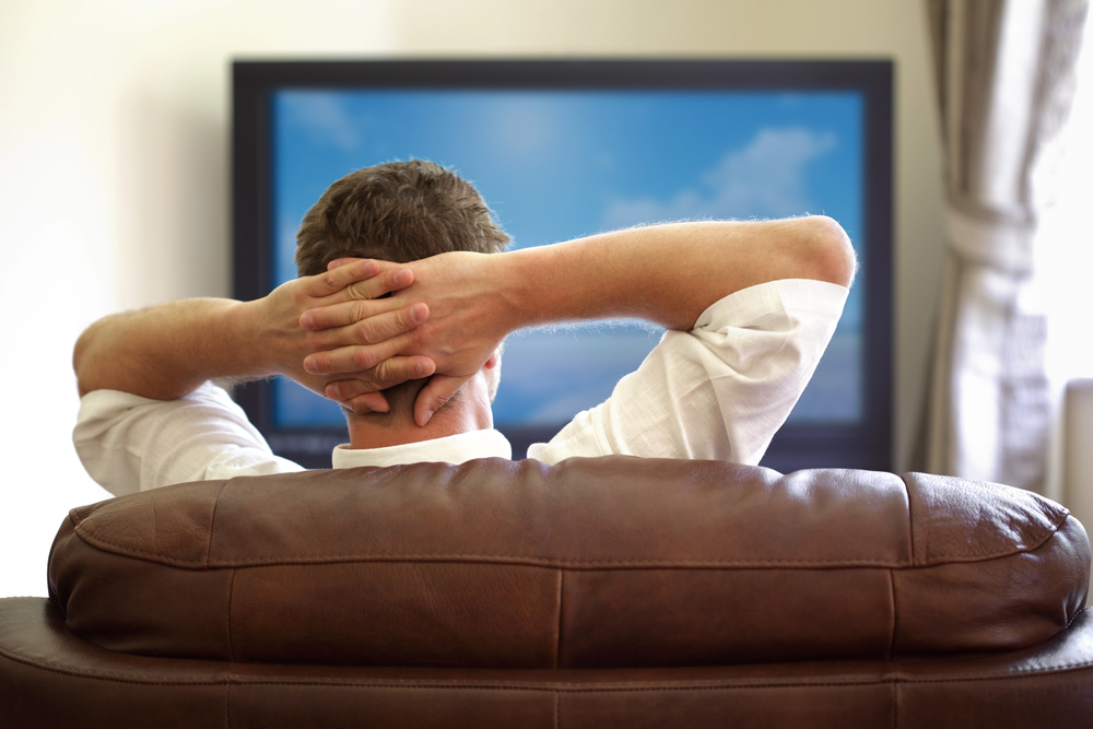 man relaxing on the couch and streaming tv