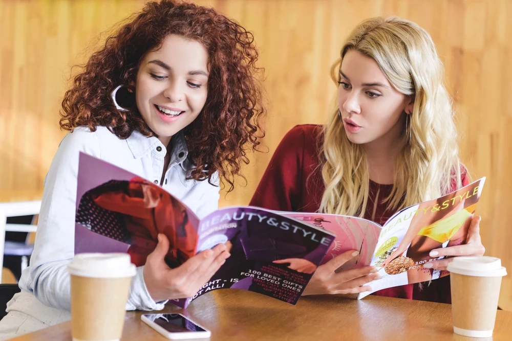 girls reading magazine advertisments