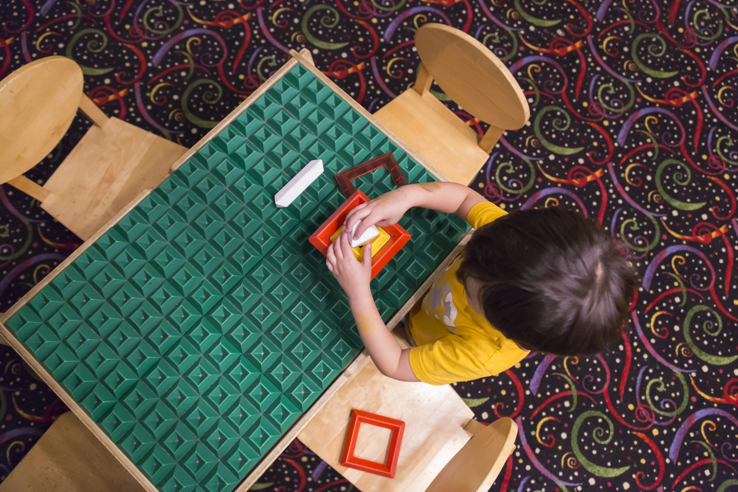 young child plays with educational blocks at an aba therapy center
