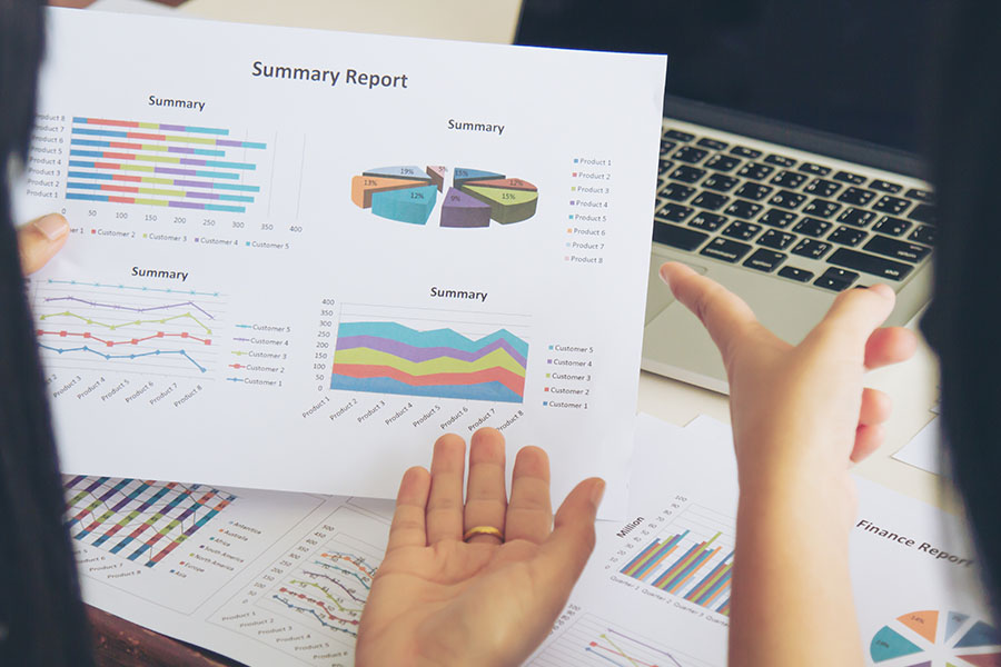 female holding a printed report showing graphs symbolizing the concept of measuring success