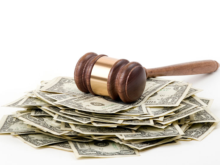 Gavel and money concept that represent fines for healthcare provider. Avoiding potential fines is one of the reasons why is hipaa compliance important in order for you to stay in the business.