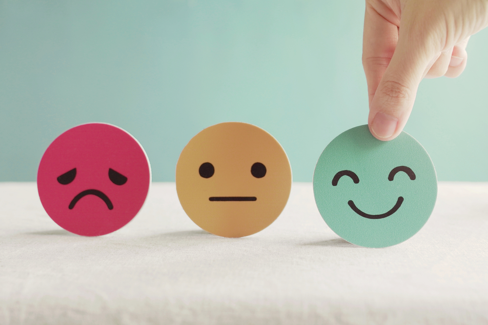 Mental Health Awareness Campaign Ideas - Hand choosing green happy smiley face paper cut