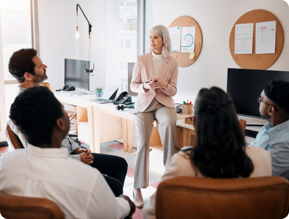 older woman talking to room full of people